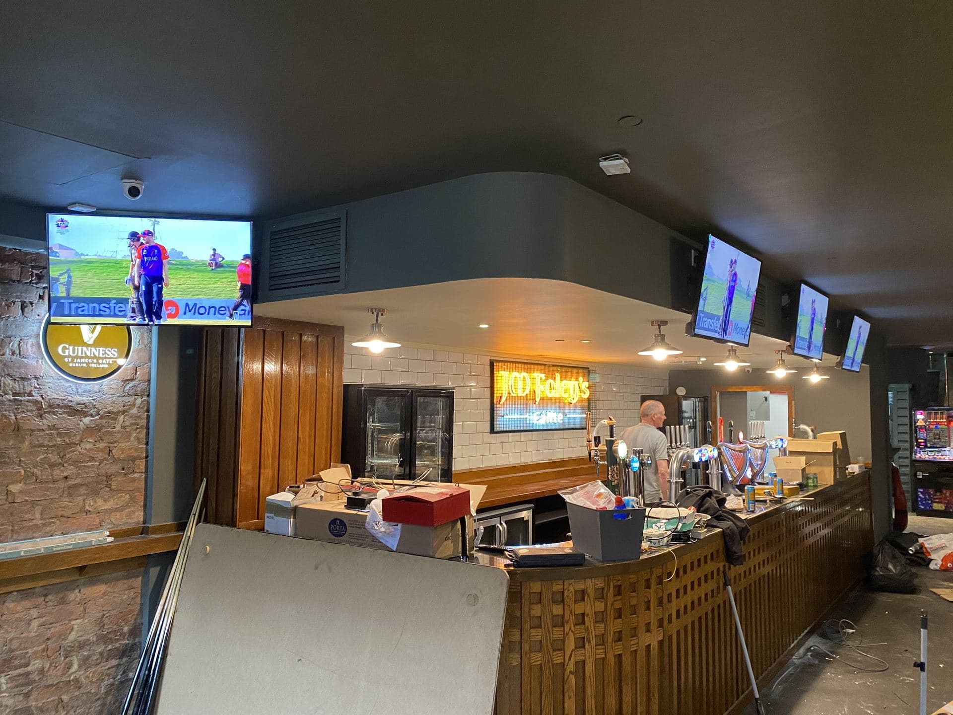 Row of TVs mounted along a bar back wall