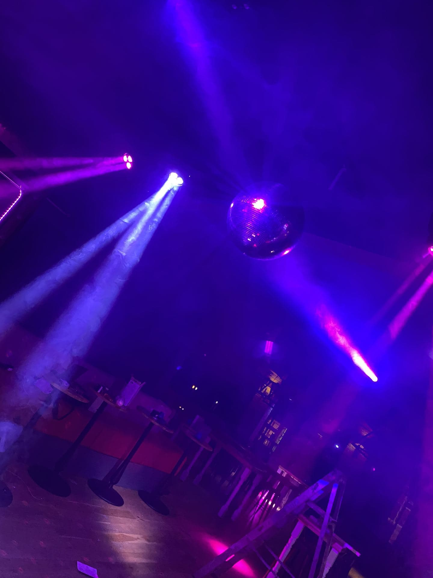 Mirror ball and moving head lights above a dance floor