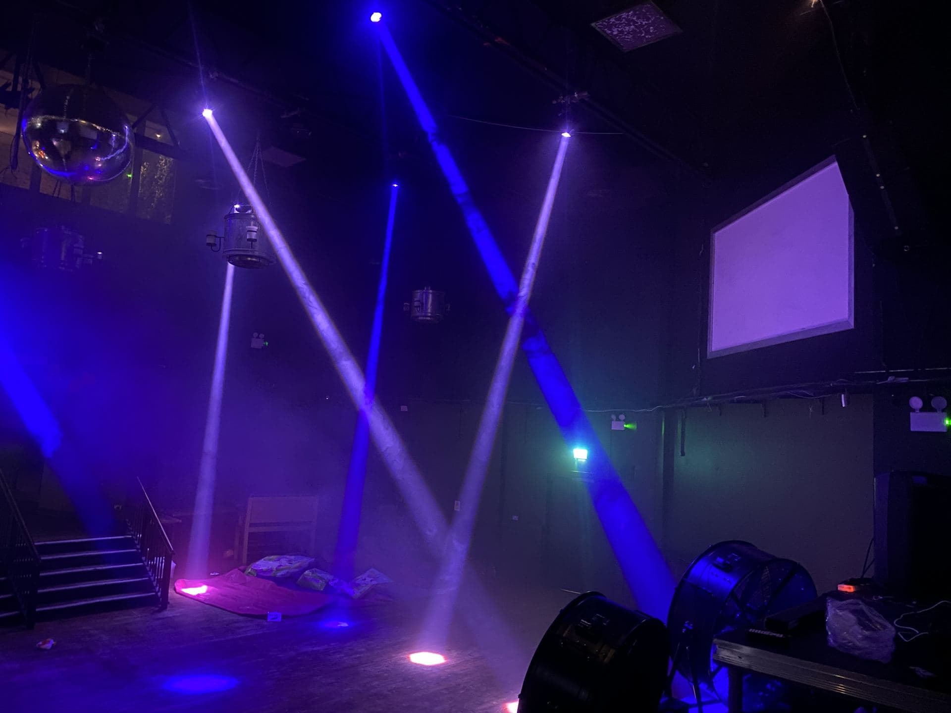 Moving head lights beaming across a nightclub room