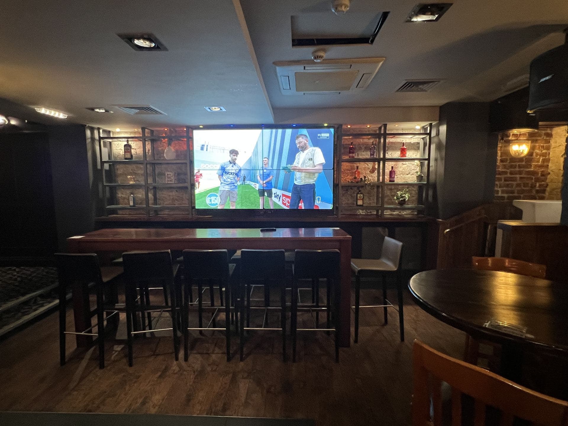 Four-screen video wall in a sports bar seating area